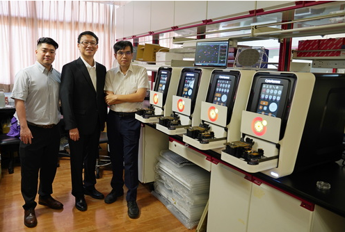 三位研究人員站在設備前面